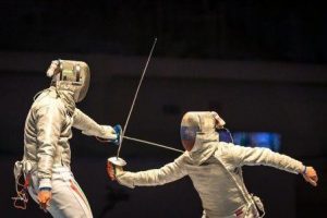 2 fencers parry and thrust, against black background